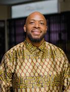 Head shot photo of Dr. Wisdom Mdumiseni Dabulizwe Dlamini, wearing a patterned shirt